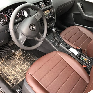 Вид сверху на чехлы из коричневой экокожи на передних сиденьях Skoda